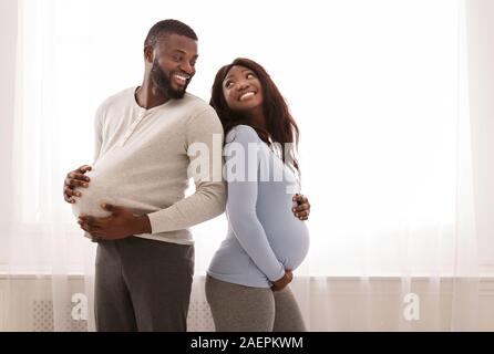 Erwartet Baby paar Vergleich der Größe Ihrer großen Bauch Stockfoto