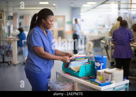 Eine Krankenschwester an einer Arbeitsstation in einem NHS Krankenstation. Der NHS ist zunehmend unter Druck, mit Mangel an der Finanzierung. Stockfoto