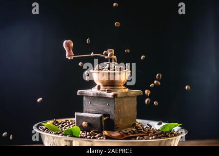 Kaffeebohnen fallen auf Holz- Vintage hand Kaffeemühle. Schleifen duftenden frisch gerösteten Kaffee Stockfoto