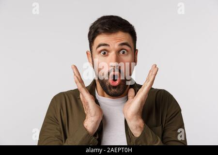 Begeistert, amüsiert und erstaunt erwachsene Mann hören Lieblingsband kommen in der Stadt, ständigen fasziniert und erstaunt, sprachlos berühren Wangen, sagen wow Stockfoto