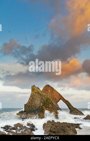 Bogen GEIGE ROCK PORTKNOCKIE Küste von Moray in Schottland stürmischen WINTER SONNENUNTERGANG MIT ORANGE farbige Wolken und ein blauer Himmel Stockfoto