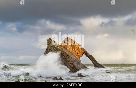 Bogen GEIGE ROCK PORTKNOCKIE Küste von Moray in Schottland stürmischen Winter Wetter eine riesige Welle schlagen GEGEN DIE FELSEN Stockfoto