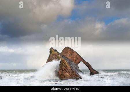 Bogen GEIGE ROCK PORTKNOCKIE Küste von Moray in Schottland stürmischen WINTER WETTER EINE GROSSE WELLE AUF DER SEITE DES ROCK FORMATION Stockfoto