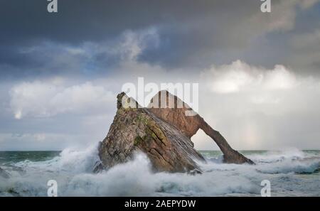 Bogen GEIGE ROCK PORTKNOCKIE Küste von Moray in Schottland stürmischen WINTER WETTER SPRAY ABSTURZ UM DIE FELSEN Stockfoto