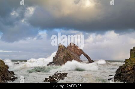 Bogen GEIGE ROCK PORTKNOCKIE Küste von Moray in Schottland stürmischen WINTER WETTER DIE FELSEN UMGEBEN VON WELLEN UND SPRÜHEN Stockfoto