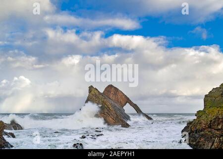 Bogen GEIGE ROCK PORTKNOCKIE Küste von Moray in Schottland stürmischen WINTER WETTER DAS MEER MIT SEHR GROSSEN WELLEN UND SPRAY AUF DEN FELSEN Stockfoto