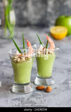 Avocado- und grüner Apfel Mousse mit Garnelen und Mandeln. Teil Vorspeise für ein Buffet oder Bankett in ein Glas. Stockfoto