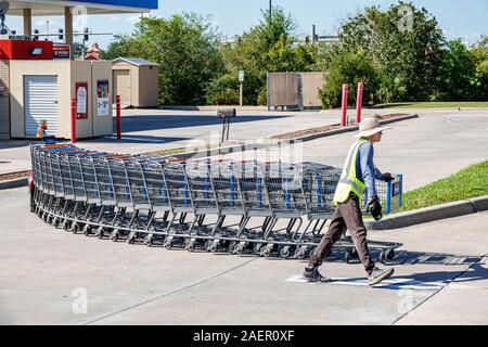 St. Saint Cloud Florida, Walmart, Kaufhaus, außen, Parkplatz, Mann, Mitarbeiter, Arbeiter, zurückkehrende Einkaufswagen abrufen, FL191110184 Stockfoto