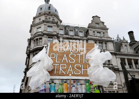 Mann Demonstrant mit Plastikflaschen mit Plakat protestieren gegen die Verwendung von Kunststoffen in der Westminster London England UK KATHY DEWITT Stockfoto