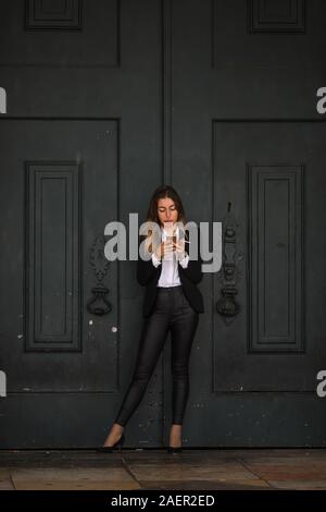 Geschäftsfrau mit Handy und Rauchen Zigarette, Sao Nicolau, Lissabon, Portugal Stockfoto