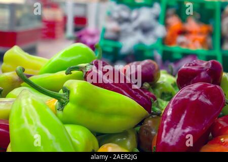 Rote, grüne und gelbe Paprika auf einem Zähler im Supermarkt. Stockfoto