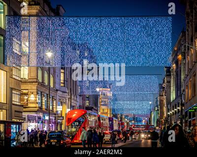 Weihnachtsbeleuchtung in der Oxford Street, London mit Käufern. Stockfoto