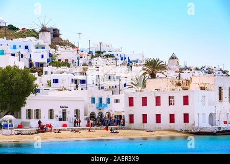 Mykonos, Griechenland - 23. April 2019: berühmte Insel weisse Häuser, Windmühle, Strand, Blick vom Meer auf den Kykladen Stockfoto