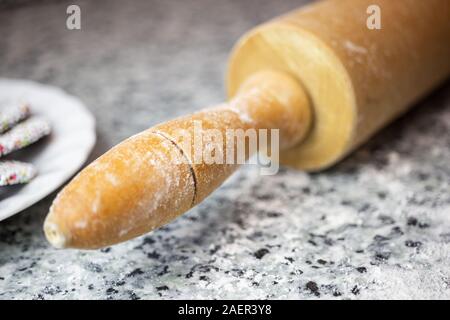 In der Nähe von Rolling Pin mit Mehl auf der Küchenarbeitsplatte. Weihnachtsbäckerei Konzept. Stockfoto