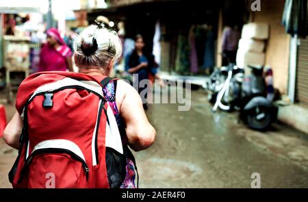 Eine weiße alte Dame zu Fuß durch in den indischen Markt. Ausländer in Indien Stockfoto
