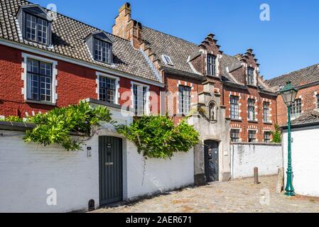 Gasse mit roten Häuser in dem kleinen Beginenhof O.L.V. Ter Hooyen / Unsere Liebe Frau von Ter Hooie/Our-Lady Hooyen in der Stadt Gent, Flandern, Belgien Stockfoto