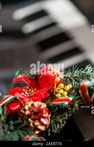 Bunte Weihnachtsdekorationen auf einem elektronischen Keyboard Synthesizer gesetzt. Stockfoto