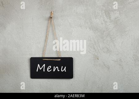 Schwarz schwarzes Brett, Tafel, Tafel mit Menü Text auf grauem Zement Wand mit Kopie Raum Stockfoto