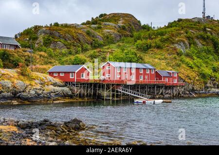 Eine rote Angeln in Sakrisoy, einem kleinen Fischerdorf in Moskenes Gemeinde auf den Lofoten Inseln in Nordland County, Norwegen mit einem Berge in Ba Stockfoto