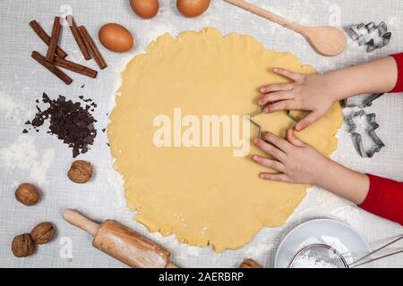 Kind schneidet Cookies von Teig Stockfoto