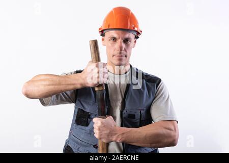 Ein Bauherr mit einem großen Schwert auf seine Schulter. Handwerker mit Helm und Arbeitskleidung. Stockfoto