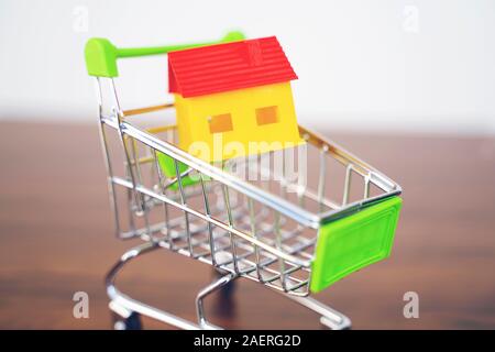Kauf eines Hauses Konzept. Modell Home in einem Warenkorb Stockfoto