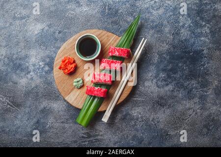 Sushi Rollen auf Holzbrett. Stein Hintergrund. Ansicht von oben Stockfoto
