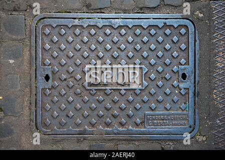 Kanaldeckel gestempelt mit Spqr-Senātus Rōmānus Populusque in Rom, Italien. Stockfoto