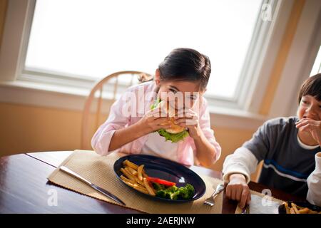 Gerne Bruder und Schwester Spaß Essen am Esstisch. Stockfoto