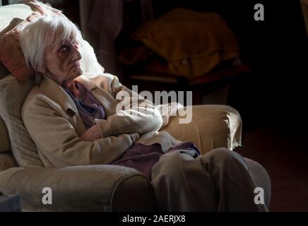 Die 90 Jahre alte Dame ist in einem isolierenden Decke abgedeckt, um warm zu bleiben und nicht in der Lage ist, ihr Haus ohne fremde Hilfe, als Sie blinde registriert ist, zu verlassen. Stockfoto