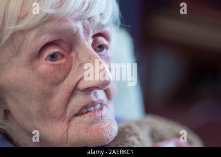 Die 90 Jahre alte Dame ist in einem isolierenden Decke abgedeckt, um warm zu bleiben und nicht in der Lage ist, ihr Haus ohne fremde Hilfe wie Sie ist blind registriert zu verlassen Stockfoto
