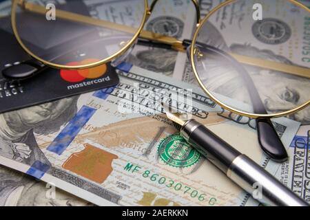 Das Finanzkonzept. Gläser und eine Mastercard auf Dollar werden. Cheboksary, Russland, am 25.11.2018.. Stockfoto