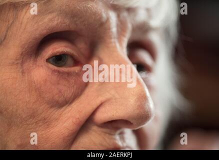 Die 90 Jahre alte Dame ist in einem isolierenden Decke abgedeckt, um warm zu bleiben und nicht in der Lage ist, ihr Haus ohne fremde Hilfe wie Sie ist blind registriert zu verlassen Stockfoto