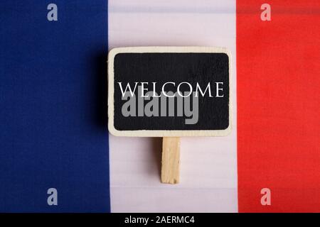 Grußansage für Reisende Konzept - Frankreich Flagge und Tafel mit Text Willkommen. Nahaufnahme Stockfoto