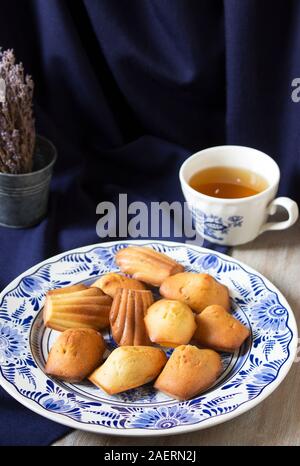 Lavendel madeleines auf einem porzellanteller auf blauem Hintergrund. Im rustikalen Stil. Stockfoto