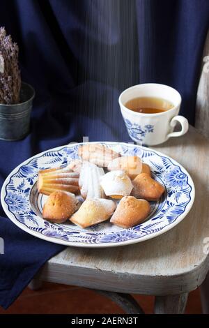 Lavendel madeleines auf einem porzellanteller auf blauem Hintergrund. Im rustikalen Stil. Stockfoto