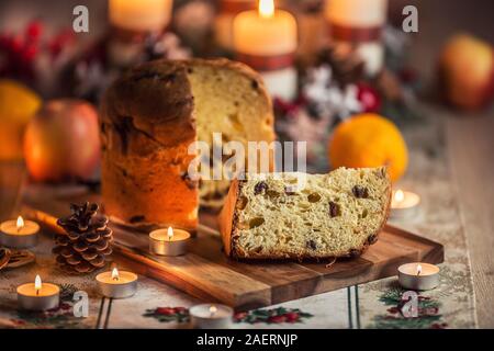 Leckere panettone auf Weihnachten Tabelle wit Dekorationen und Adventskranz und Kerzen. Stockfoto