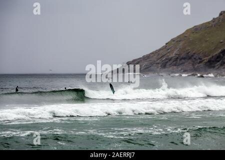 Arktis Surfer Surfen in der Norwegischen See. Unstad, Norwegischen Dorf auf der Lofoten. Norwegische Küste. Winter Wasser Sport. Stockfoto