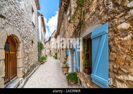 Einer typischen schmalen, verwinkelten Gasse mit französischen Bleu Fensterläden im mittelalterlichen Dorf Tourrettes sur Loup, Frankreich. Stockfoto