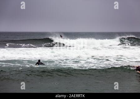 Arktis Surfer Surfen in der Norwegischen See. Unstad, Norwegischen Dorf auf der Lofoten. Norwegische Küste. Winter Wasser Sport. Stockfoto