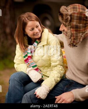 Junges Paar warme Kleidung tragen, sehen sich gegenseitig während der Sitzung in einen Hof. Stockfoto