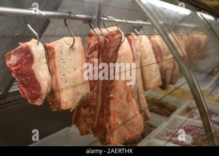Fleisch hängt an Haken an der Metzgerei Stockfoto