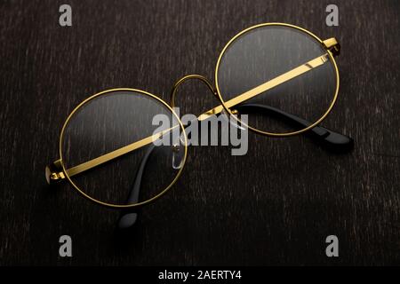 Gold Brille auf einem dunklen Hintergrund. Stockfoto