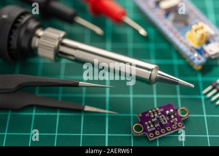 Elektronik Entwicklung Konzept. Hobbys sind Elektronik. Lötkolben und Werkzeuge auf dem Desktop. Stockfoto