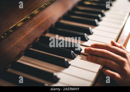 In der Nähe der Finger der Hand eines Kindes ruht auf Piano keys. Stockfoto