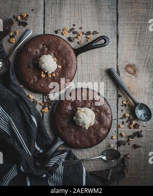 Blick von oben auf die Brownies mit Eis und Muttern in Gusseisen Skillet. Stockfoto