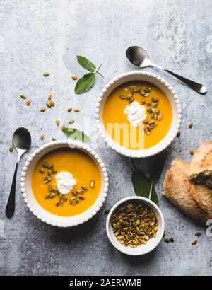 Blick von oben auf die Schalen von butternut Kürbis Suppe auf grauem Hintergrund. Stockfoto