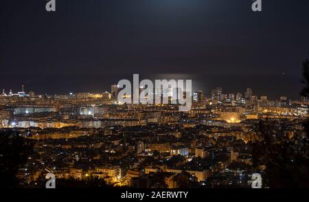 Barcelona Skyline bei Nacht mit dem Mond über dem Meer Stockfoto