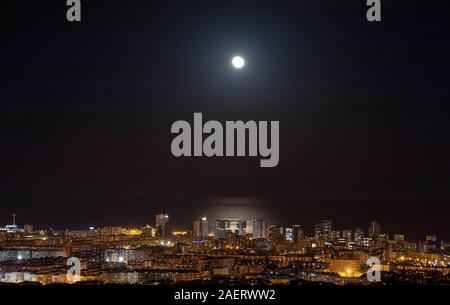 Barcelona Skyline bei Nacht mit dem Mond über dem Meer Stockfoto