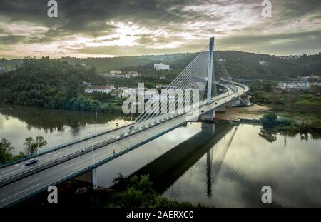 Blick auf die Ponte Rainha Santa Isabel in Coimbra über den Fluss Mondego mit der Sonne im Rücken Stockfoto